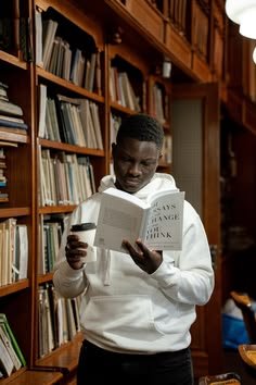 A reader standing in a library with a book