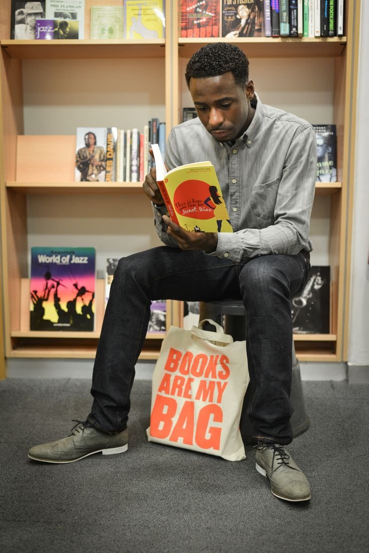 A customer reading beside a Books Are My Bag tote